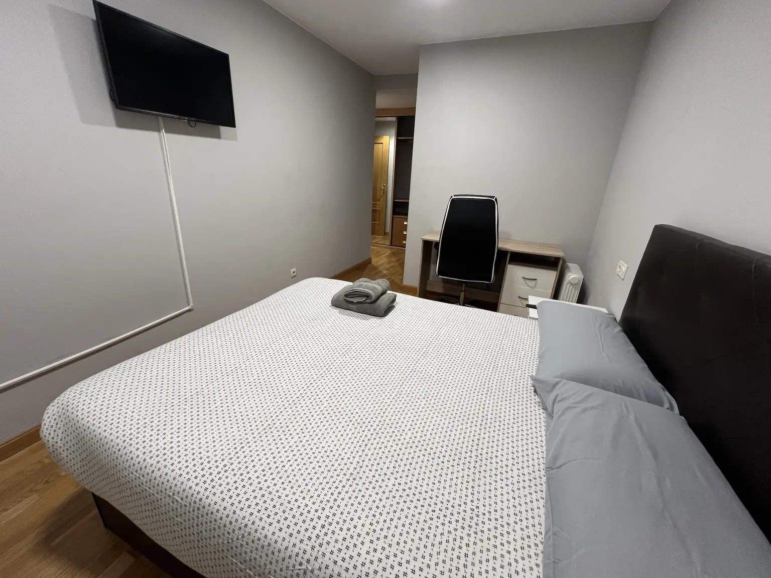 Dormitorio matrimonial con televisión y escritorio