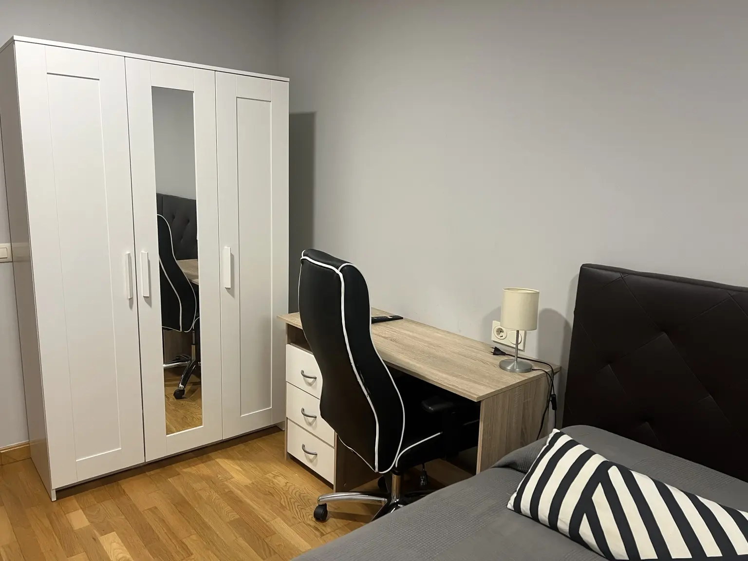 Dormitorio con cama, armario y zona de escritorio