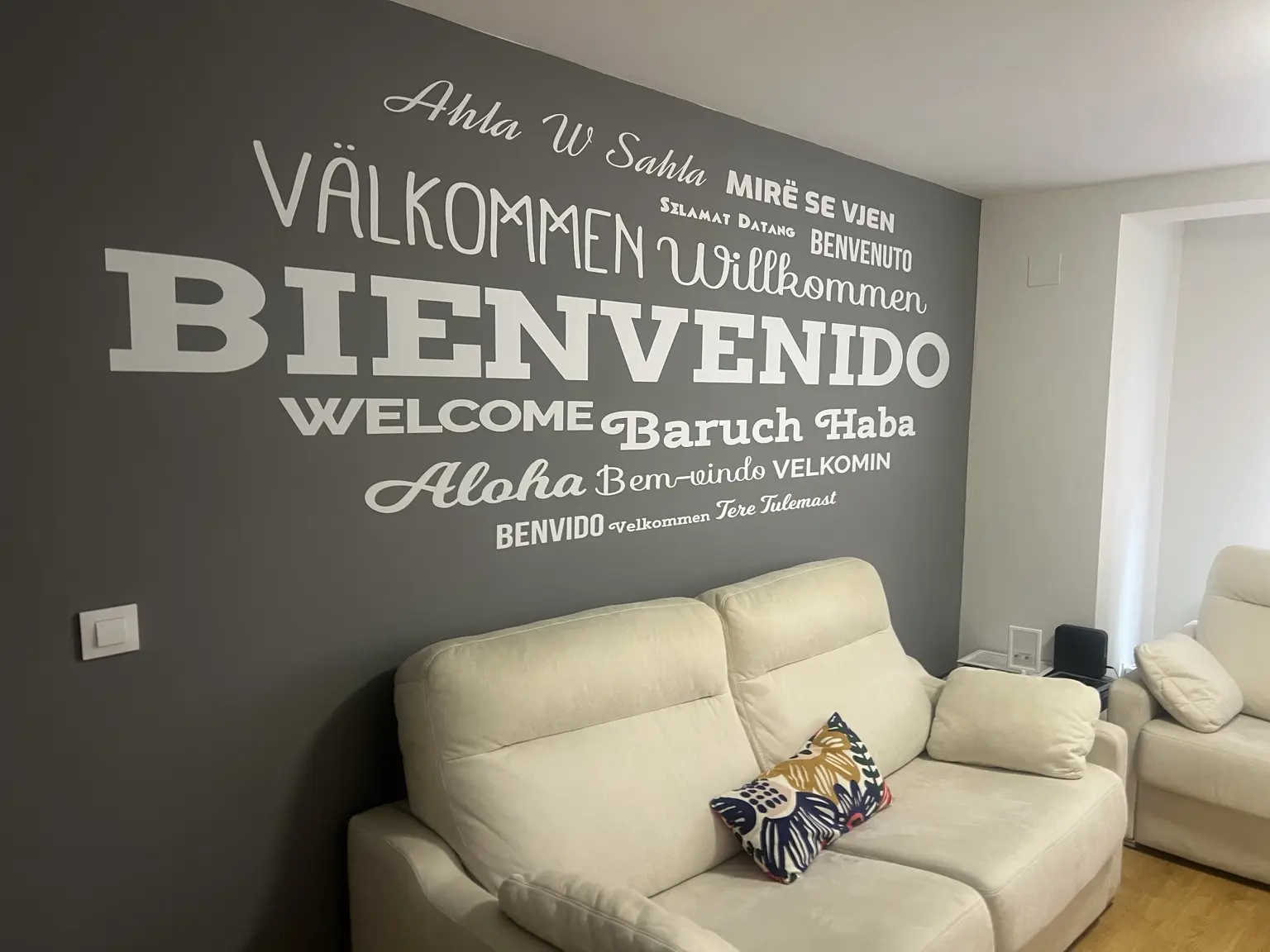 Salón con sofá y pared de bienvenida